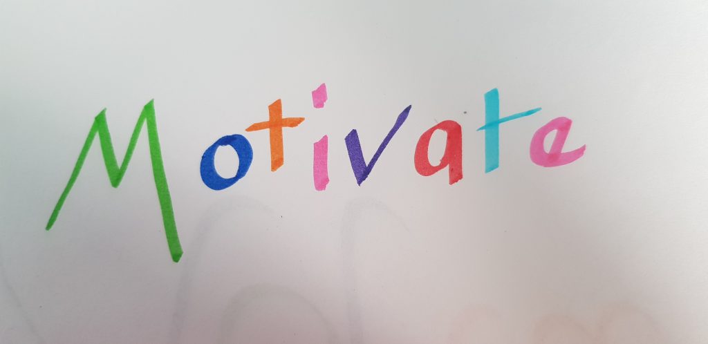 the word motivate in rainbow coloured felt tips.