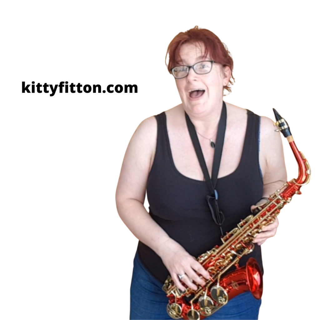 show kitty fitton grinning with a shiny red saxophone in her hands.
