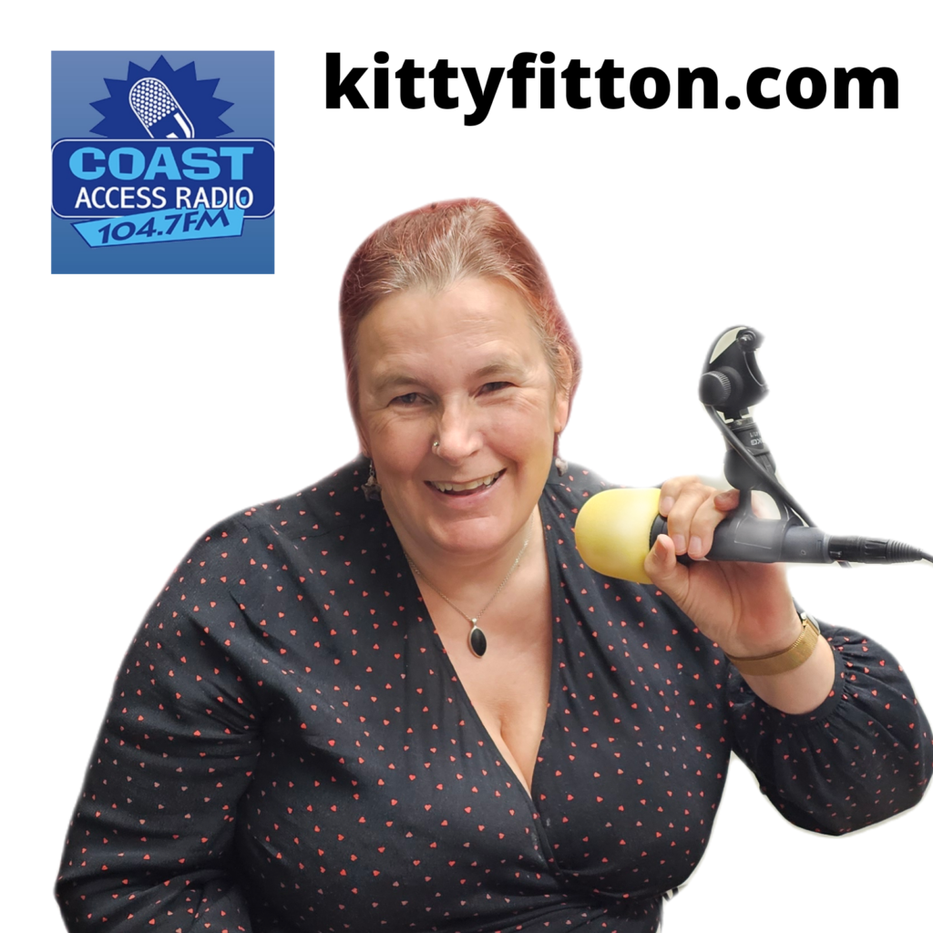 image of kitty fitton laughing holding a microphone.
