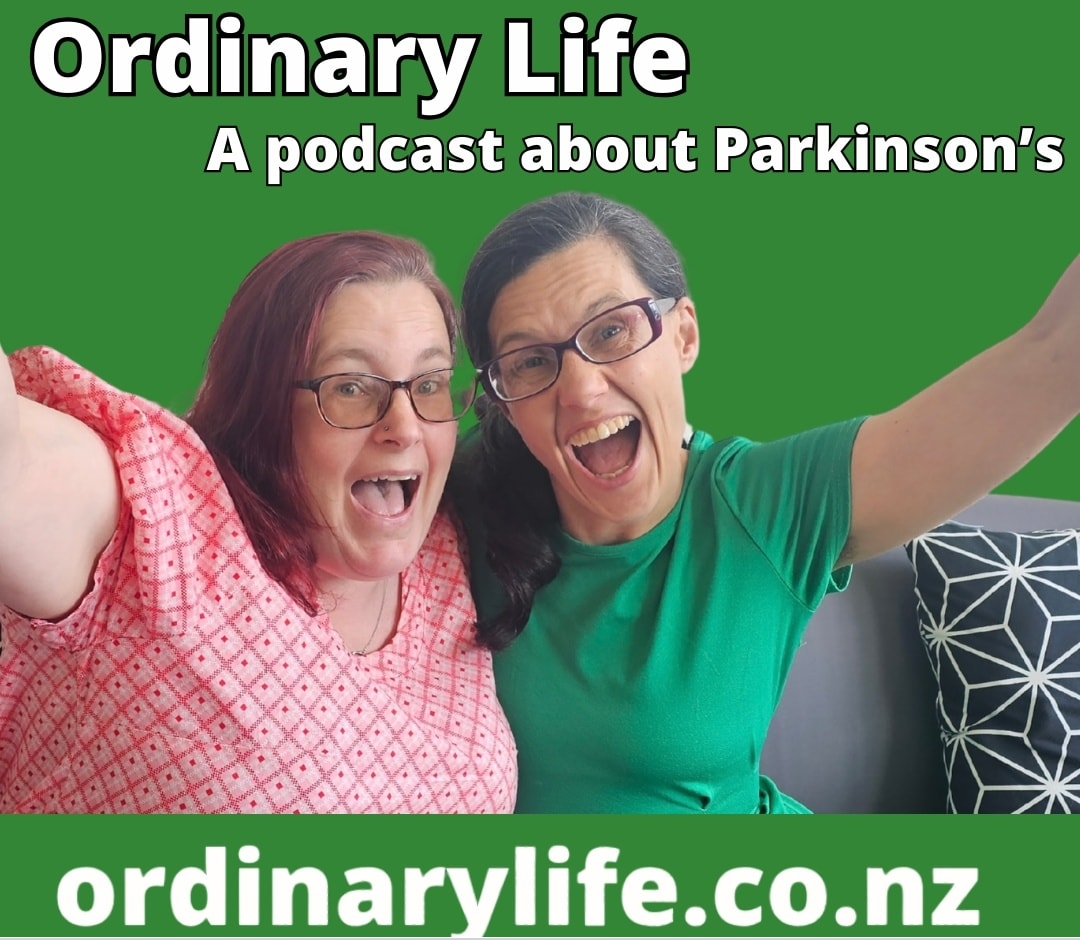 Picture shows Kitty and Emma laughing with arms out stretched against the green background