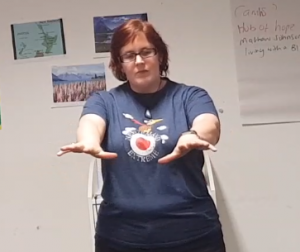 image of kitty holding her arms out in front of her as she gives a talk to Leeds Central Division St John Ambulance. 
